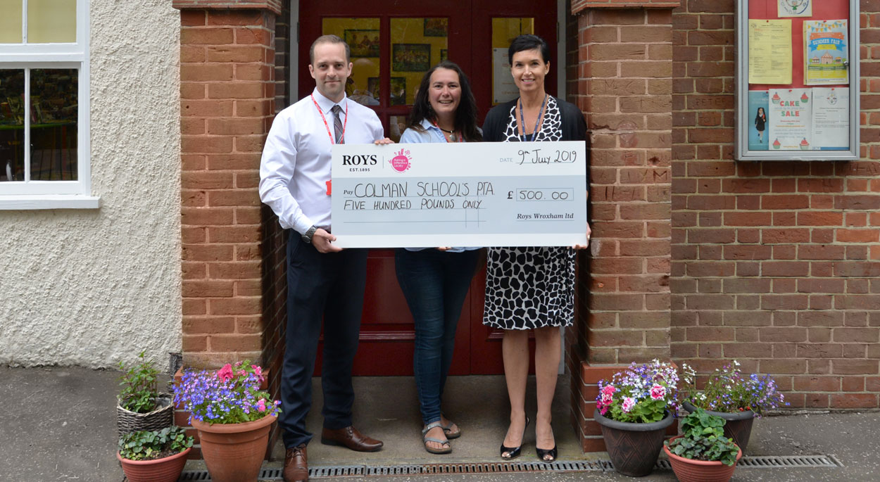 Photo of Dan Dicks, Roys of Bowthorpe store manager presenting a cheque to Susan Chedgey, chair of the PTA and Rachel Smith, Deputy headteacher of Colman Junior School