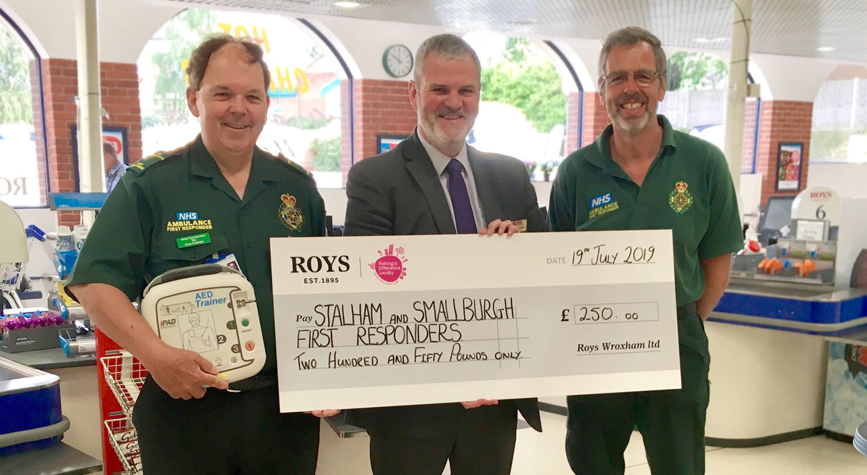 Photo of Darren Coles, Roys of Wroxham Food Hall store manager presenting a cheque to Stalham and Smallburgh First Responders